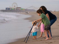 ADA Training Toddler, mom and child holding braces on the seashore