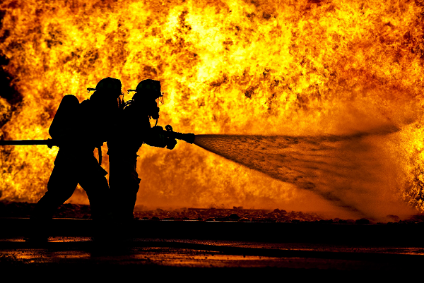 two firefighters put out a blaze